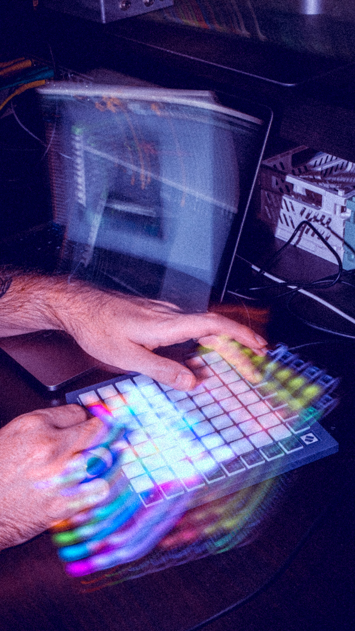 Mains d'une personne jouant sur un contrôleur MIDI FLPAD, entourées d'effets de lumière circulaires et colorés.