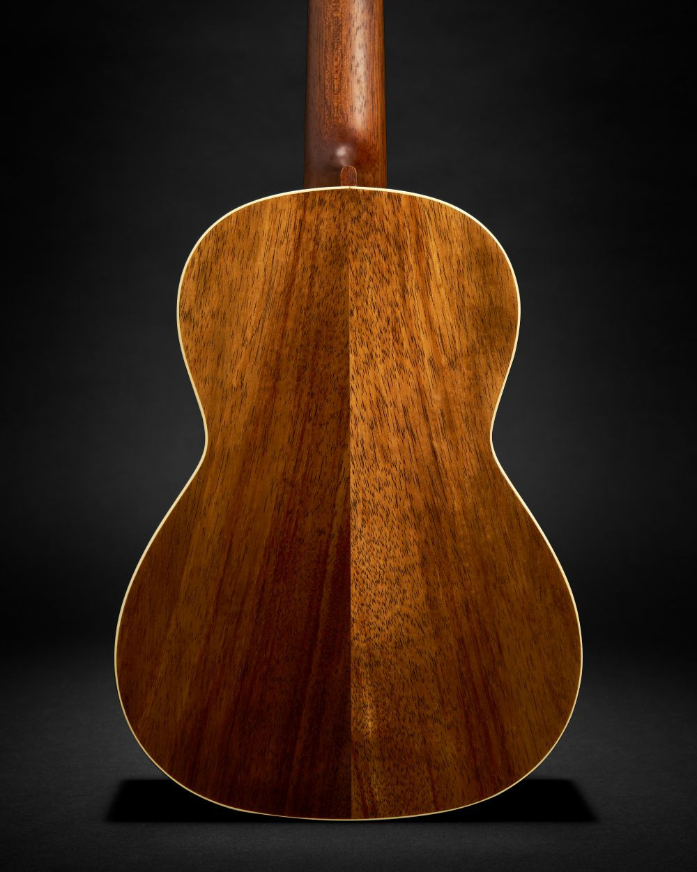 Ukulélé Martin O’ahu TKE Uke Burst avec une finition bois verni en dégradé, présenté sur un fond noir uni.