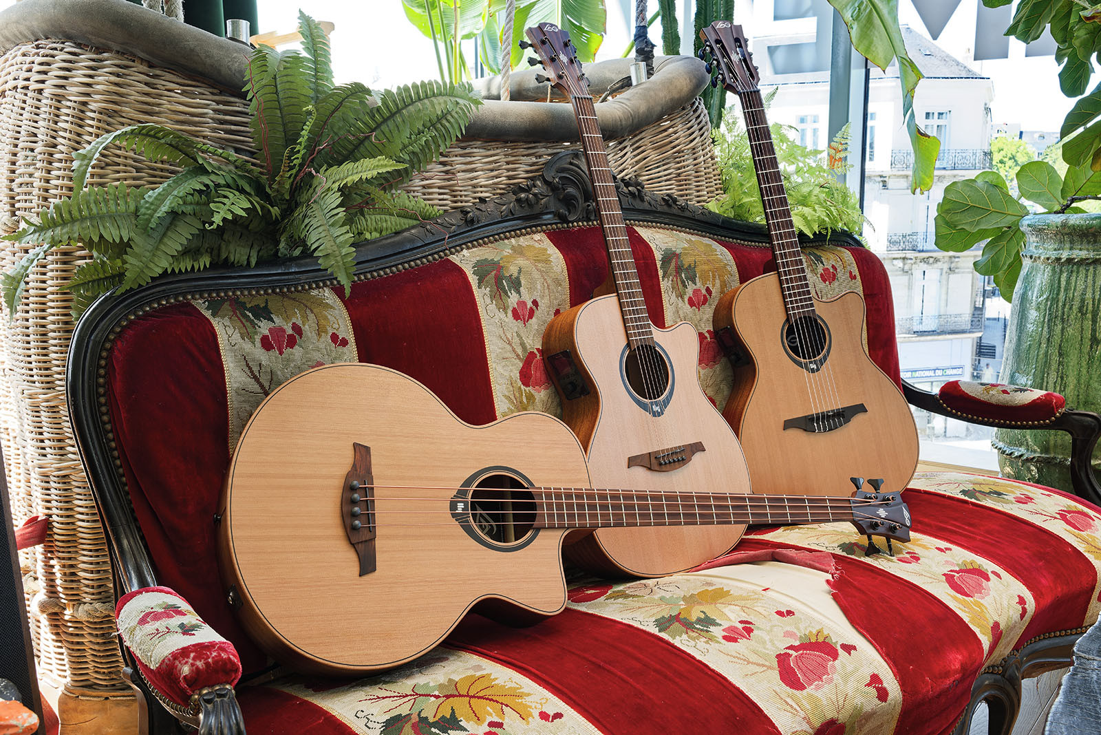 3 guitares Lâg Hyvibe sur un canapé rayé