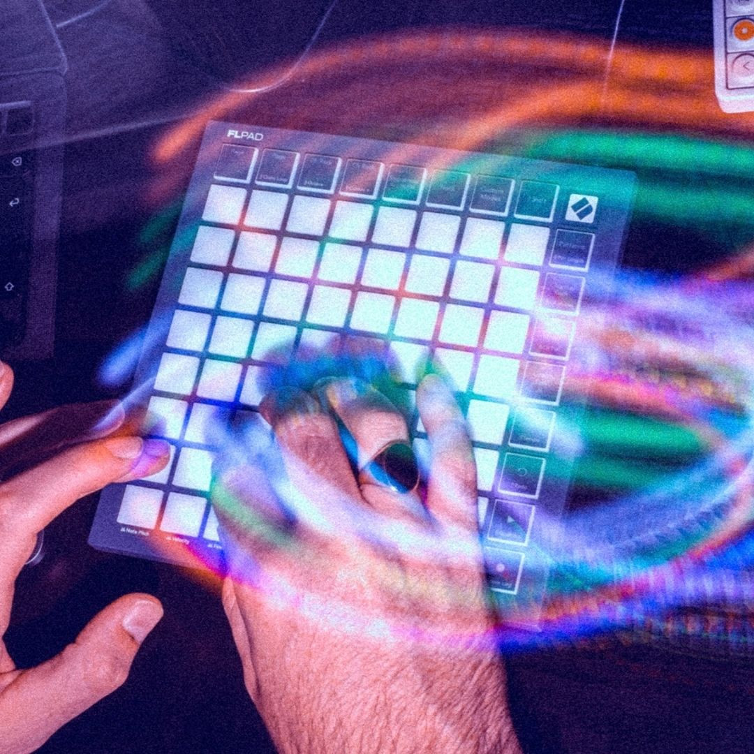 Mains d'une personne jouant sur un contrôleur MIDI FLPAD, entourées d'effets de lumière circulaires et colorés.